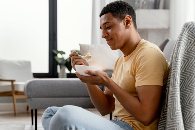 Portrait man at home eating