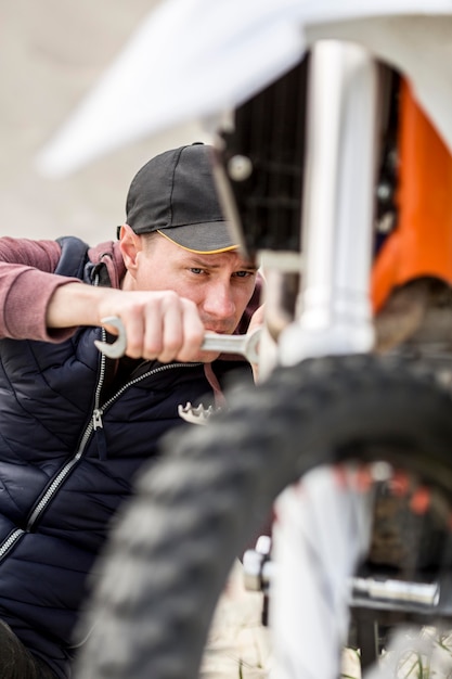 Free Photo portrait of man trying to fix motorbike