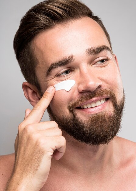 Portrait of man using face cream