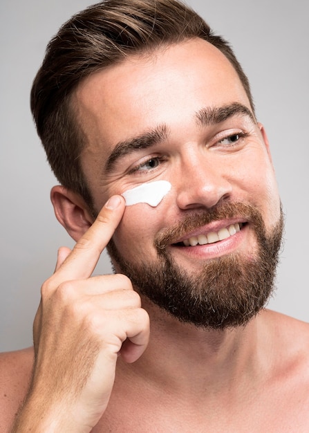 Portrait of man using face cream