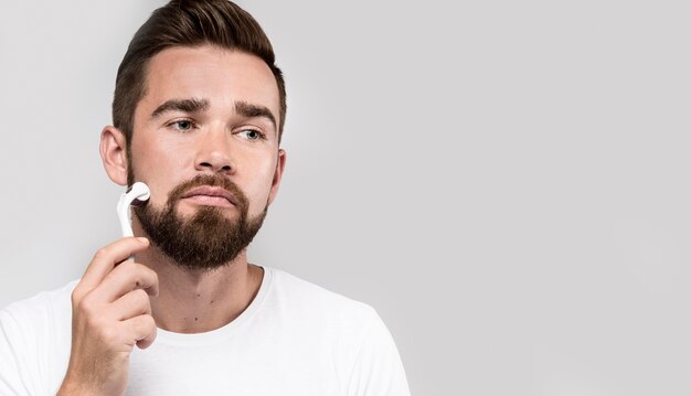 Portrait of man using a face roller