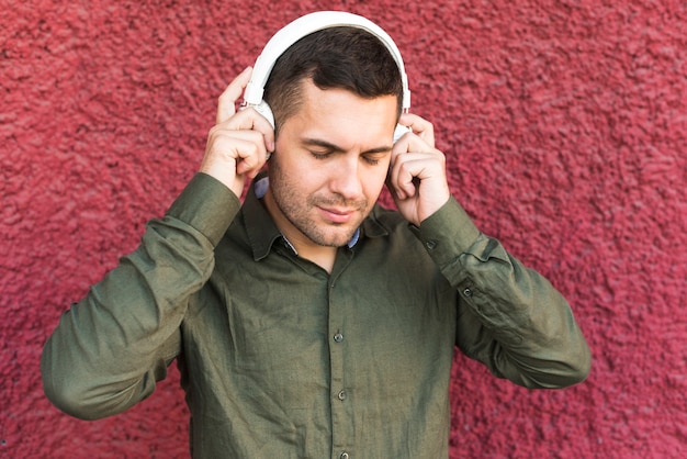 Free photo portrait of man wearing headphone listening music