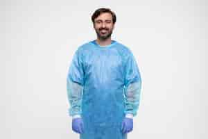 Free photo portrait of man wearing medical gown and gloves