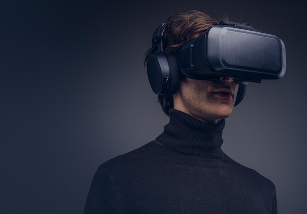 Portrait of a man wearing virtual reality device isolated on a d