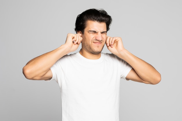 Portrait of a man in white t-shirt covering his ears