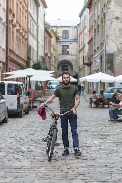 Free Photo portrait of a man with bicycle at outdoors