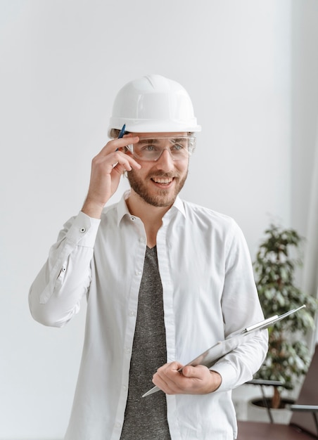 Portrait man with helmet at office