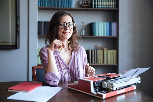 Portrait of a mature smiling authoress sitting at the desk