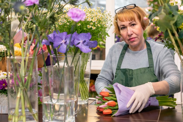 Free Photo portrait of mature woman holding flowers