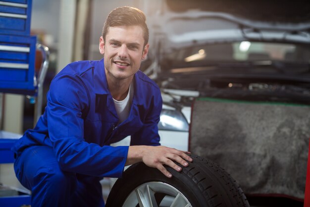 Portrait of mechanic with a tyre