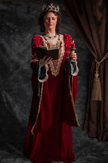 Free Photo portrait of medieval queen with book and candle