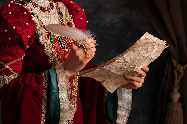 Portrait of medieval queen with quill writing on paper