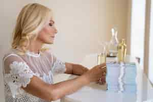 Free photo portrait of middle-aged blonde rich woman with champagne glass and banknotes