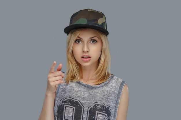 Free photo portrait of modern hip hop female in a cap isolated on grey background.