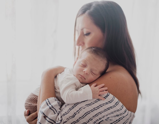 Free Photo portrait of mother holding little child