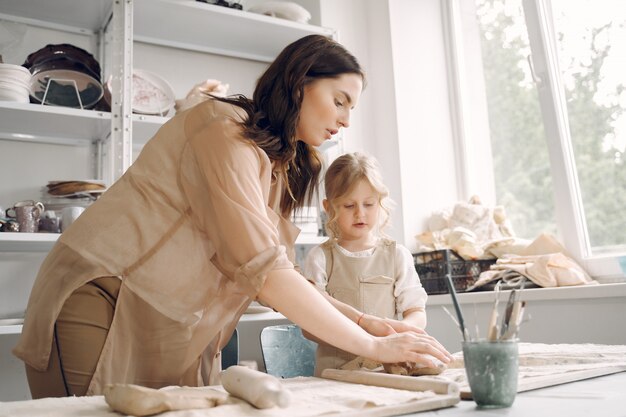 Portrait of mother and little girl shaping clay together