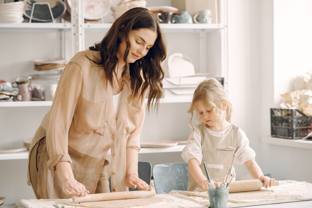 Portrait of mother and little girl shaping clay together