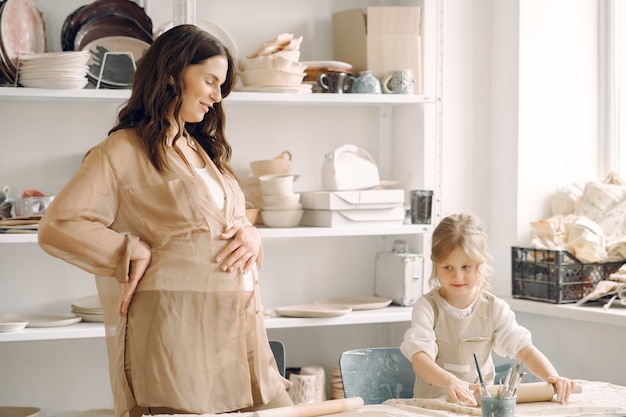 Portrait of mother and little girl shaping clay together