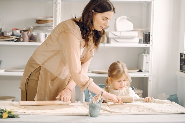 Portrait of mother and little girl shaping clay together