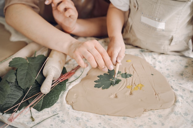 Free photo portrait of mother and little girl shaping clay together