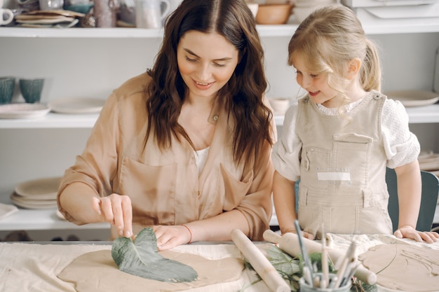 Free photo portrait of mother and little girl shaping clay together