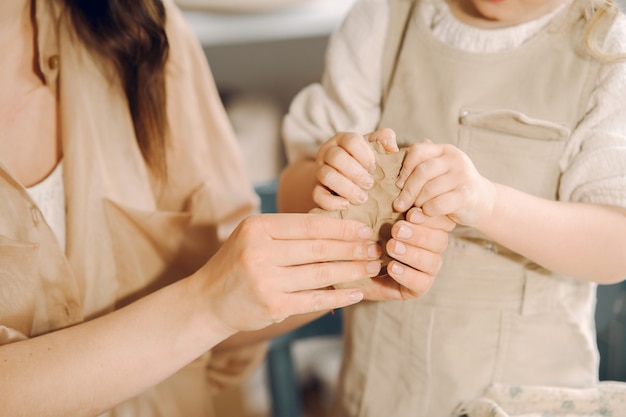 Free Photo portrait of mother and little girl shaping clay together