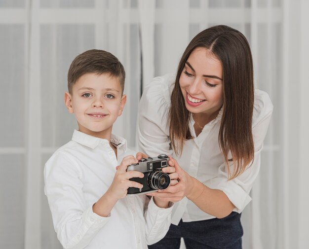 Portrait of mother teaching son how to use a camera