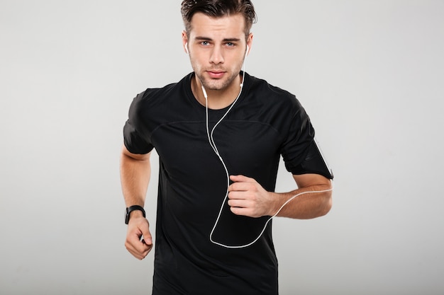 Portrait of a motivated young man athlete in earphones