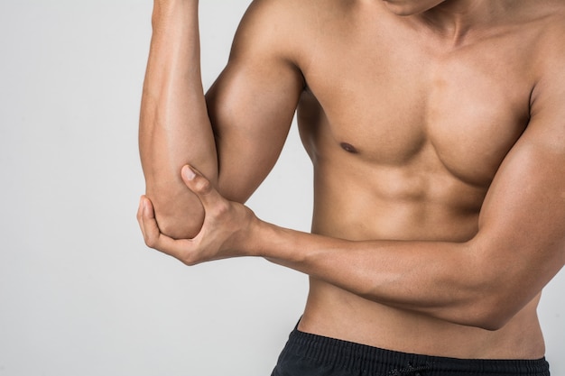 Portrait of a muscle man having elbow pain isolated on white background