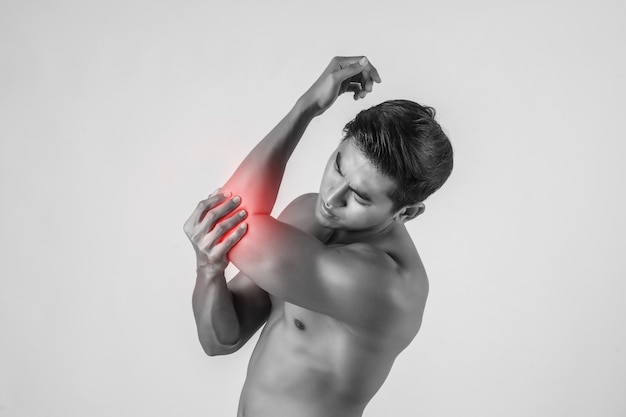 Free photo portrait of a muscle man having elbow pain isolated on white background