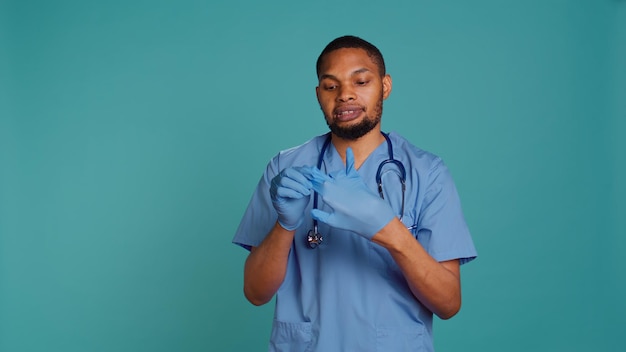 Free photo portrait of nurse putting on protective latex gloves