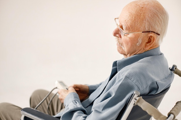 Portrait of an old man on a wheelchair isolated on a white background