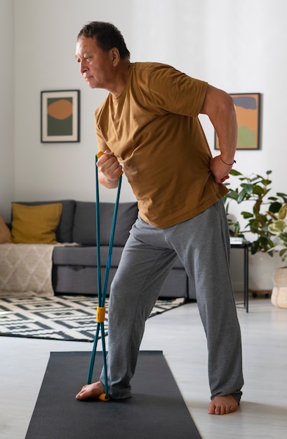 Portrait of older man exercising at home