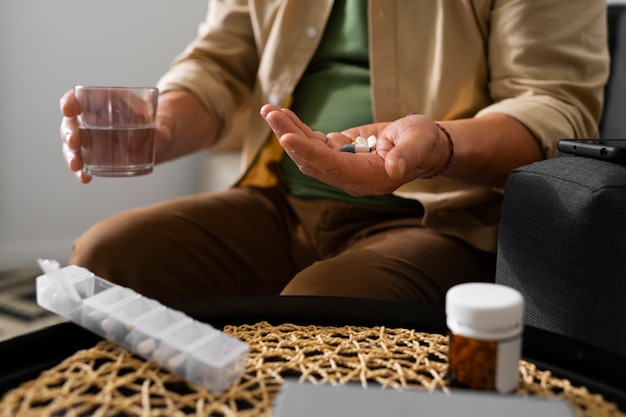 Free Photo portrait of older man taking his pills at home