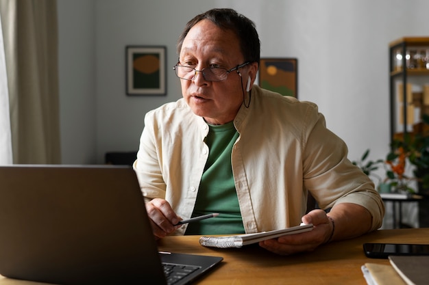 Portrait of older man using laptop at home