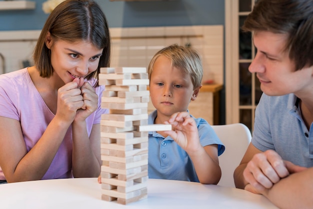 Portrait of parents playing jenga with son