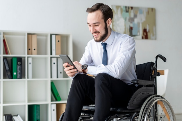 Portrait of positive adult man using mobile phone