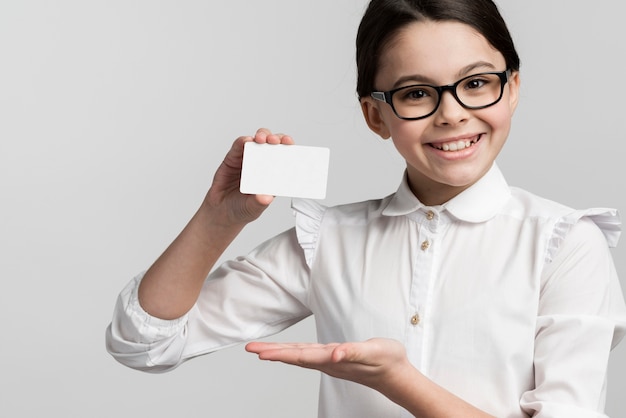 Portrait of positive young girl holding business card