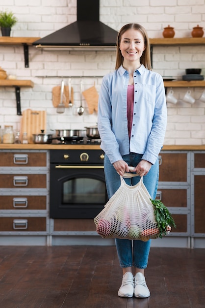 Free Photo portrait of positive young woman holding organic vegetables