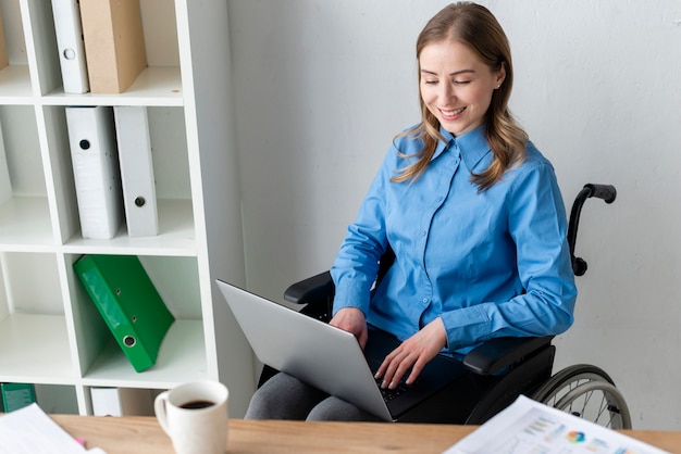 Portrait of positive young woman working on a laptop