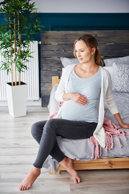 Portrait of pregnant woman resting at bedroom