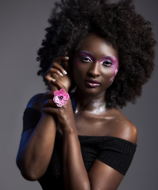 Portrait of a pretty African-American female with beautiful makeup wearing a flower ring