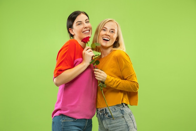 Free Photo portrait of pretty charming girls in casual outfits isolated on green studio wall