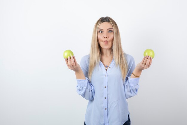 portrait of a pretty girl model standing and holding fresh apples.