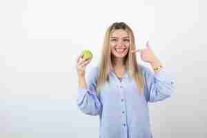 Free photo portrait pretty girl model standing and holding a green fresh apple.