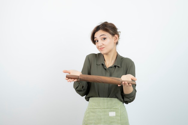 Free photo portrait of pretty woman in apron holding a rolling pin . high quality photo