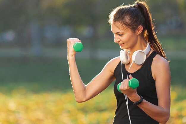 Portrait of pretty woman using fitness weights