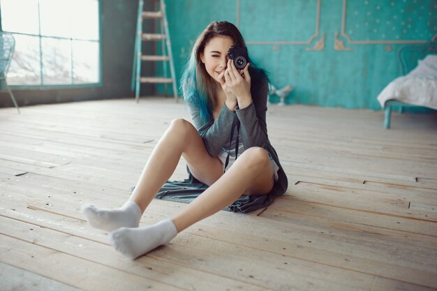 Portrait of pretty young girl taking picture on film camera