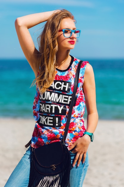 Free Photo portrait of pretty young sensual stunning woman with blond hairs and sunglasses posing on the paradise tropical beach