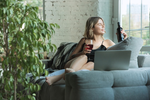 Portrait of pretty young woman in modern apartment in the morning. Resting, calm, salisfied. Youth and wellness concept.